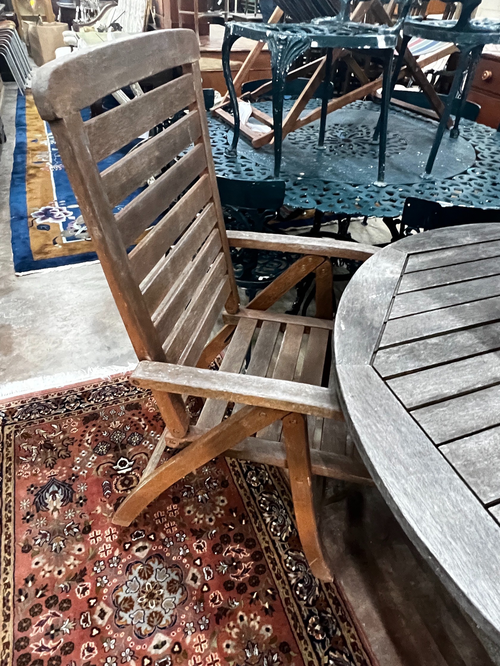 A circular weathered teak folding garden table and four teak folding armchairs, stamped Royal Craft, table 110cm diameter height 74cm